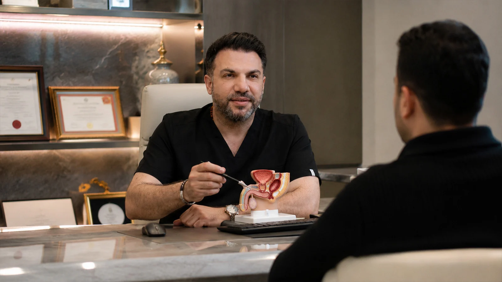 Assoc. Prof. Dr. Z&uuml;lf&uuml; Sertkaya explaining penile implant options to a patient using an anatomical model