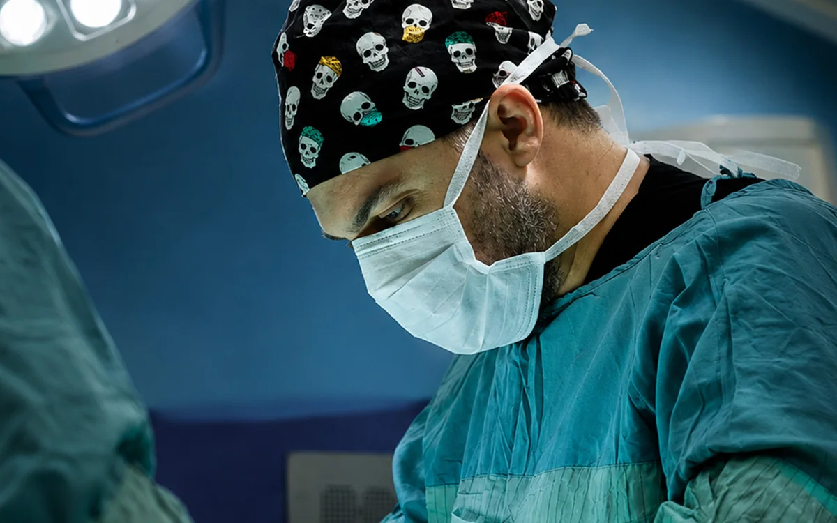 Assoc. Prof. Dr. Z&uuml;lf&uuml; Sertkaya in surgical gown and mask during an operation